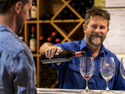 Winemaker Michael Bourke, pouring a wine tasting into a glass